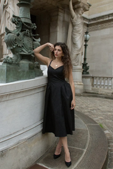 a lady wears a black midi spaghetti strap dress